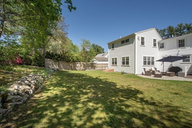 rear view of property with fence, a lawn, an outdoor living space, and a patio area