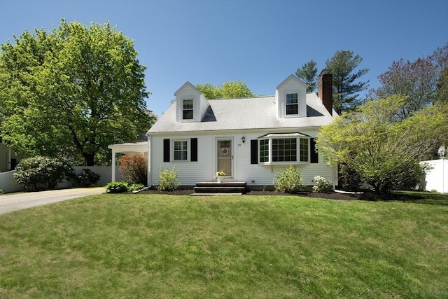 cape cod house with fence, a chimney, driveway, and a front yard