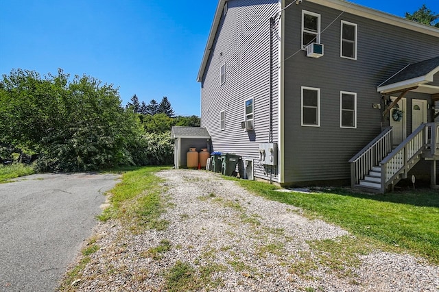 view of property exterior with a shed and cooling unit