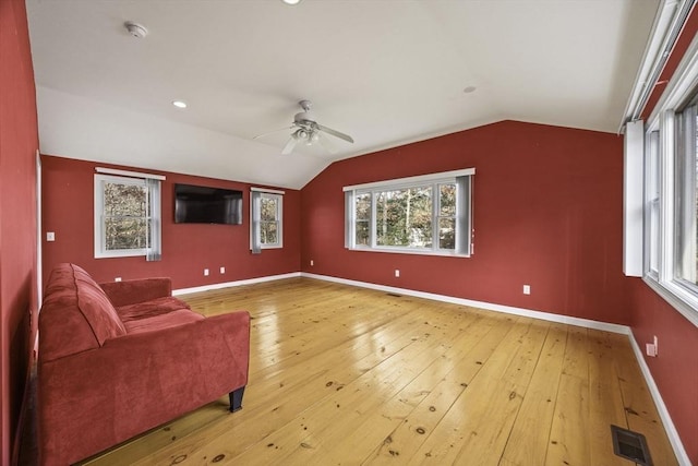 unfurnished living room with vaulted ceiling, plenty of natural light, and hardwood / wood-style floors