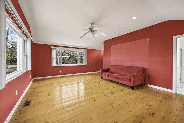 living room with ceiling fan, lofted ceiling, and light hardwood / wood-style floors