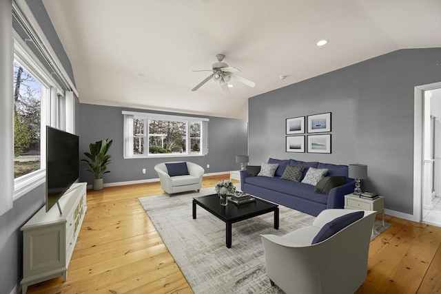 living room featuring lofted ceiling, plenty of natural light, and light hardwood / wood-style floors