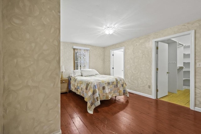 bedroom featuring a spacious closet, a closet, and light wood-type flooring