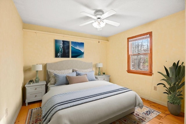 bedroom with ceiling fan and light hardwood / wood-style flooring