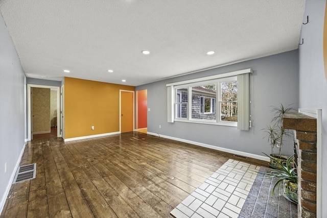 unfurnished living room featuring a textured ceiling and dark hardwood / wood-style flooring