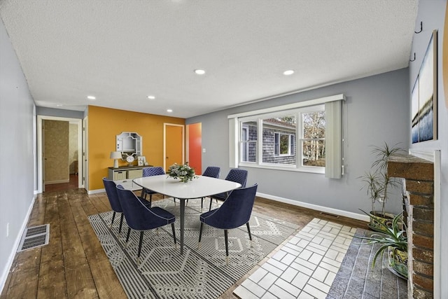 dining area featuring dark hardwood / wood-style flooring and a textured ceiling