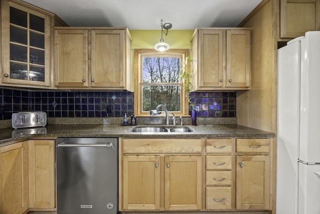 kitchen featuring decorative light fixtures, backsplash, stainless steel dishwasher, sink, and white refrigerator