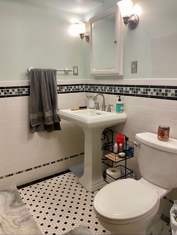 bathroom with tile walls, toilet, and tile patterned floors