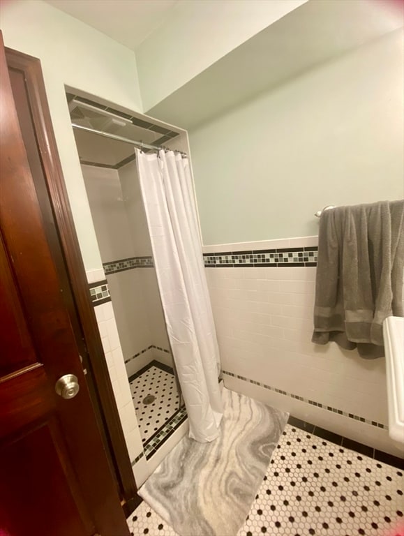 bathroom with a shower with curtain, tile walls, and tile patterned floors