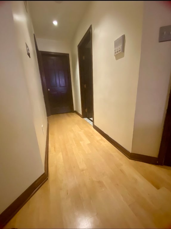 hallway with light hardwood / wood-style floors