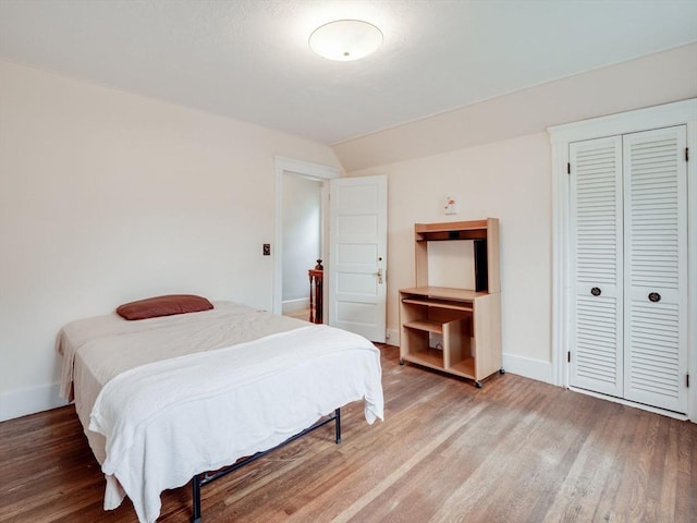 bedroom featuring vaulted ceiling, hardwood / wood-style flooring, and a closet