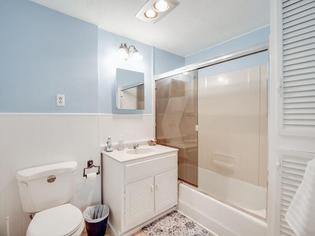 full bathroom featuring tile patterned flooring, bath / shower combo with glass door, vanity, and toilet