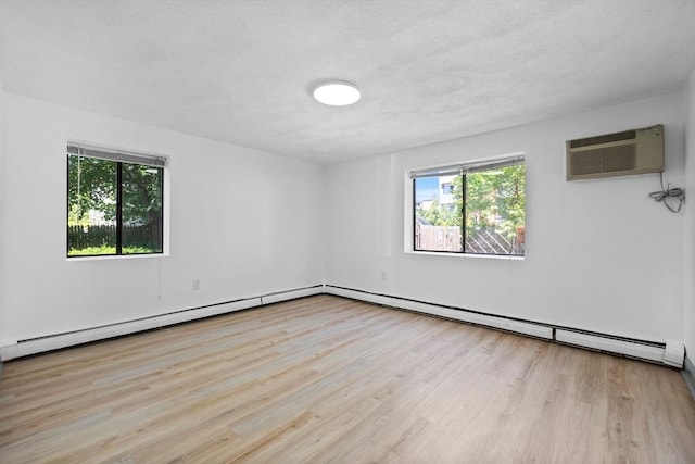 84 Grant St Unit 7, Somerville, MA 02145 - unfurnished room with a wall unit AC, plenty of natural light, wood finished floors, and a baseboard radiator