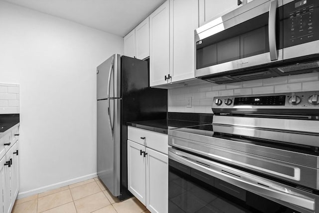 84 Grant St Unit 7, Somerville, MA 02145 - kitchen featuring stainless steel appliances, tasteful backsplash, dark countertops, and white cabinetry
