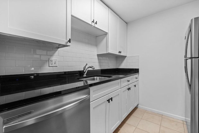 84 Grant St Unit 7, Somerville, MA 02145 - kitchen featuring appliances with stainless steel finishes, tasteful backsplash, white cabinets, and light tile patterned floors