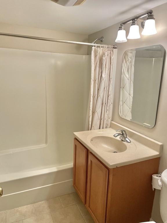 1500 Worcester Rd Unit 631, Framingham, MA 01702 - bathroom featuring vanity, shower / bath combo with shower curtain, and tile patterned floors