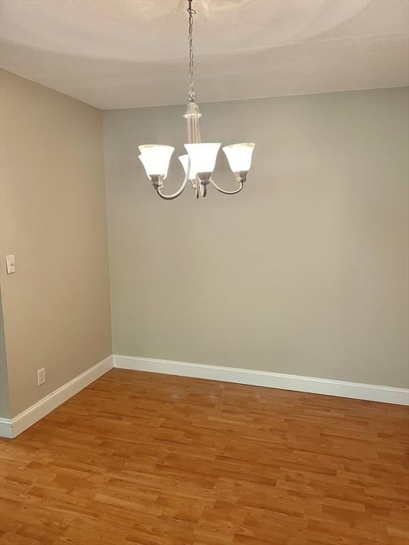 1500 Worcester Rd Unit 631, Framingham, MA 01702 - spare room featuring light wood-style floors and a chandelier