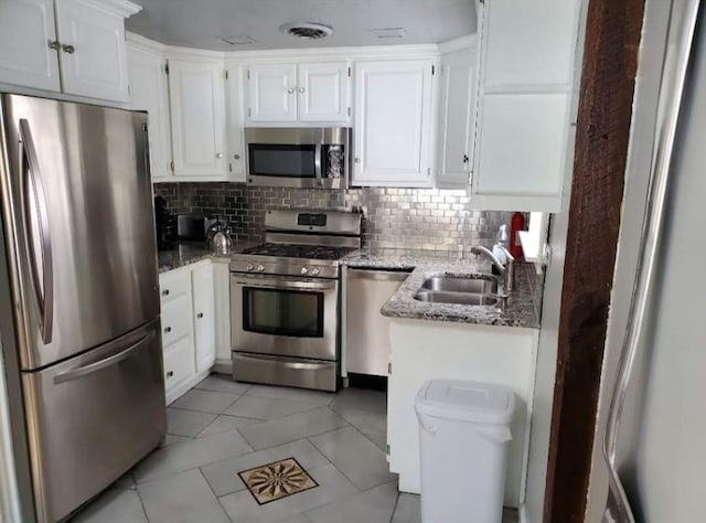 31-33 Mathews Dr, Wayland, MA 01778 - kitchen featuring appliances with stainless steel finishes, stone countertops, white cabinets, and backsplash