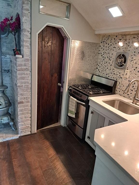 31-33 Mathews Dr, Wayland, MA 01778 - kitchen featuring stainless steel gas range, tasteful backsplash, light countertops, dark wood finished floors, and a wood stove