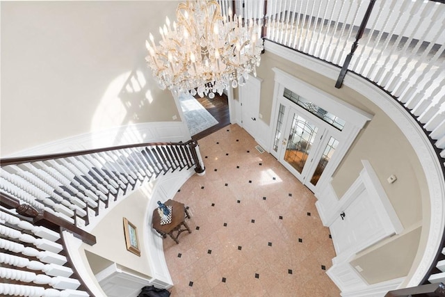 entrance foyer featuring visible vents, a high ceiling, and a chandelier