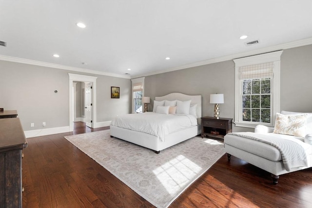 bedroom with multiple windows, wood finished floors, visible vents, and baseboards