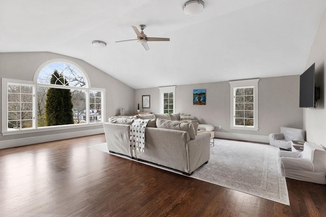 living area featuring baseboards, wood finished floors, ceiling fan, and vaulted ceiling