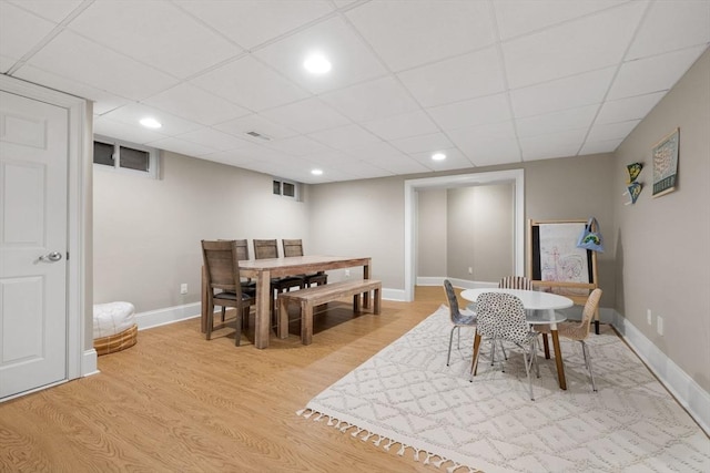 dining room with recessed lighting, baseboards, light wood-type flooring, and a paneled ceiling