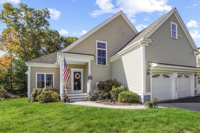 traditional-style house with a garage, a front lawn, aphalt driveway, and roof with shingles