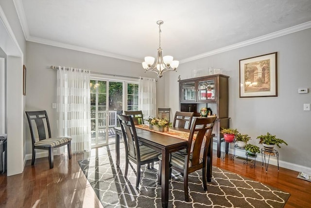 dining room with baseboards, an inviting chandelier, ornamental molding, and wood finished floors