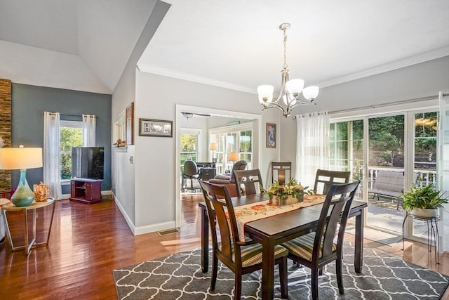 dining space featuring visible vents, wood finished floors, baseboards, a notable chandelier, and ornamental molding