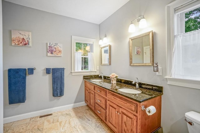 bathroom with a sink, a wealth of natural light, and toilet