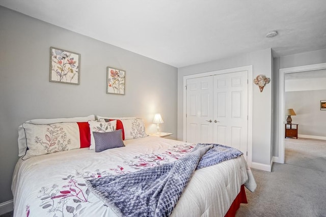 carpeted bedroom featuring a closet and baseboards