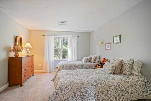 bedroom with visible vents, baseboards, and light carpet