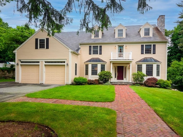 14 Nassau Dr, Winchester, MA 01890 - view of front facade with a front yard, a balcony, driveway, and a chimney