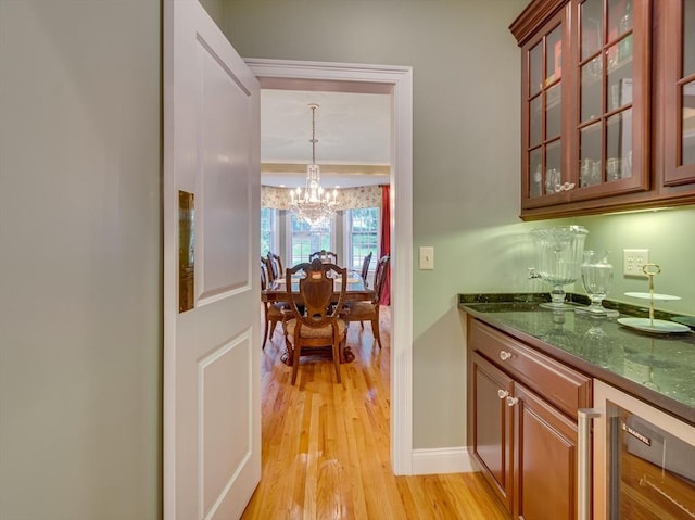 14 Nassau Dr, Winchester, MA 01890 - bar with a dry bar, an inviting chandelier, light wood-style floors, and baseboards