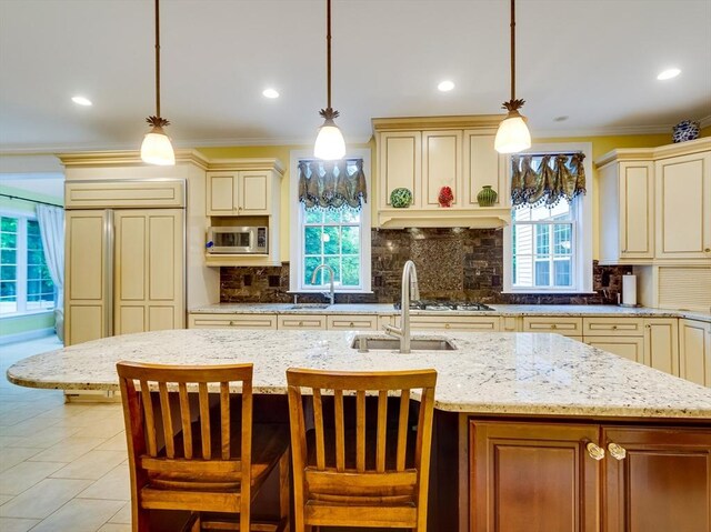 14 Nassau Dr, Winchester, MA 01890 - kitchen featuring light stone counters, stainless steel microwave, ornamental molding, and cream cabinetry