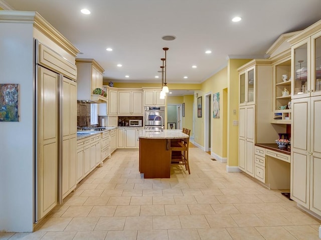 14 Nassau Dr, Winchester, MA 01890 - kitchen with a kitchen bar, crown molding, cream cabinets, and a center island with sink