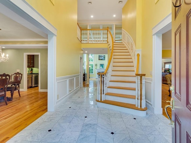 14 Nassau Dr, Winchester, MA 01890 - foyer with a chandelier, a decorative wall, a wainscoted wall, and stairway