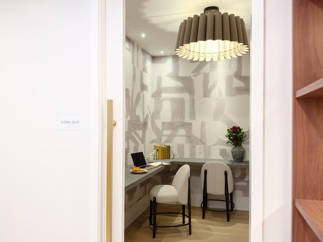 office space with built in desk and light wood-type flooring