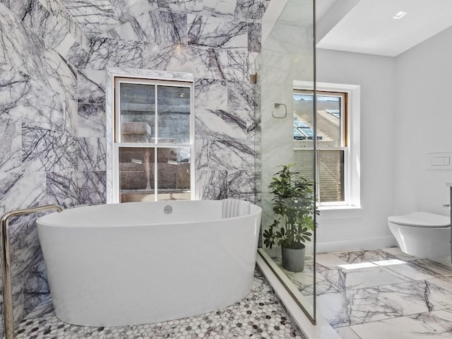 bathroom featuring tile walls, a tub, tile patterned floors, and toilet