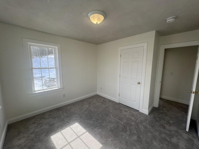 unfurnished bedroom with dark colored carpet