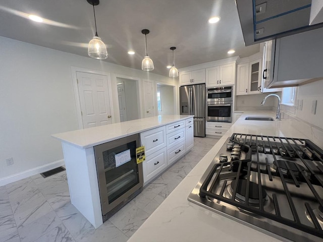 kitchen featuring wine cooler, sink, a center island, stainless steel appliances, and white cabinets