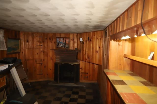 interior space featuring wooden walls, a fireplace, and dark floors