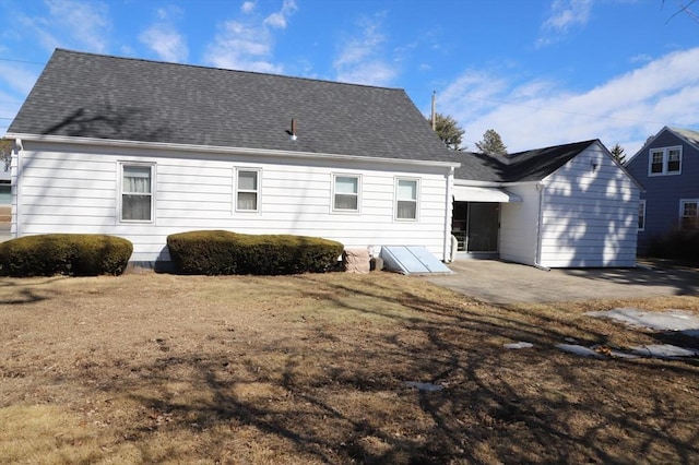 back of property featuring a patio and roof with shingles