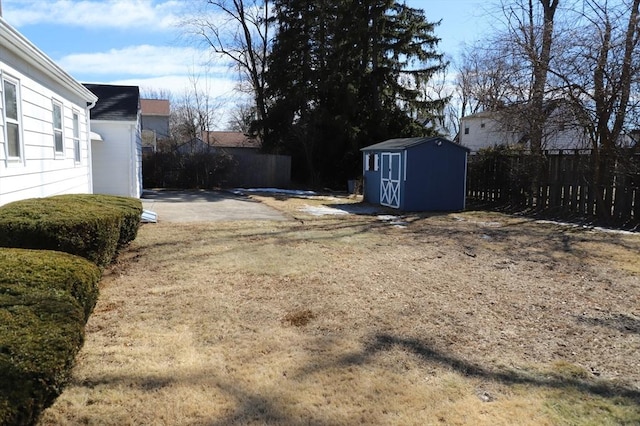 view of yard with an outdoor structure, a storage unit, and fence