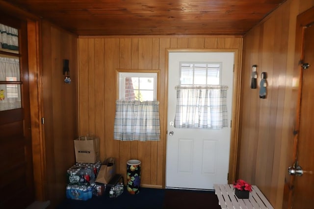 doorway to outside with wood walls and wooden ceiling