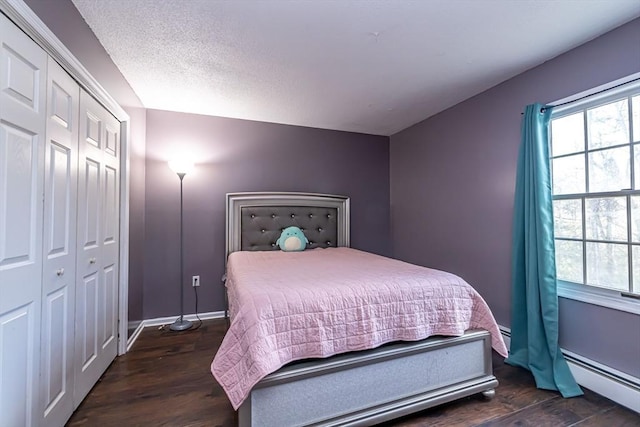 bedroom featuring a textured ceiling, a closet, dark wood-type flooring, and a baseboard radiator