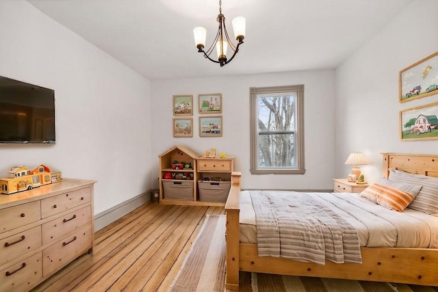 bedroom with light wood-type flooring, baseboards, and a chandelier