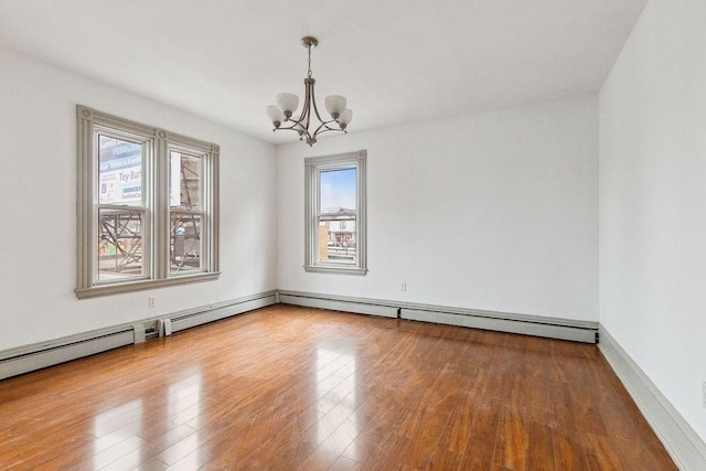 unfurnished room featuring a notable chandelier and wood finished floors