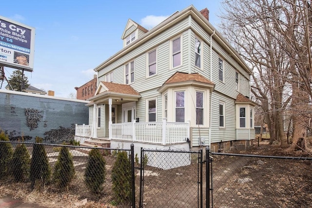 view of front of house featuring a fenced front yard, covered porch, and a gate